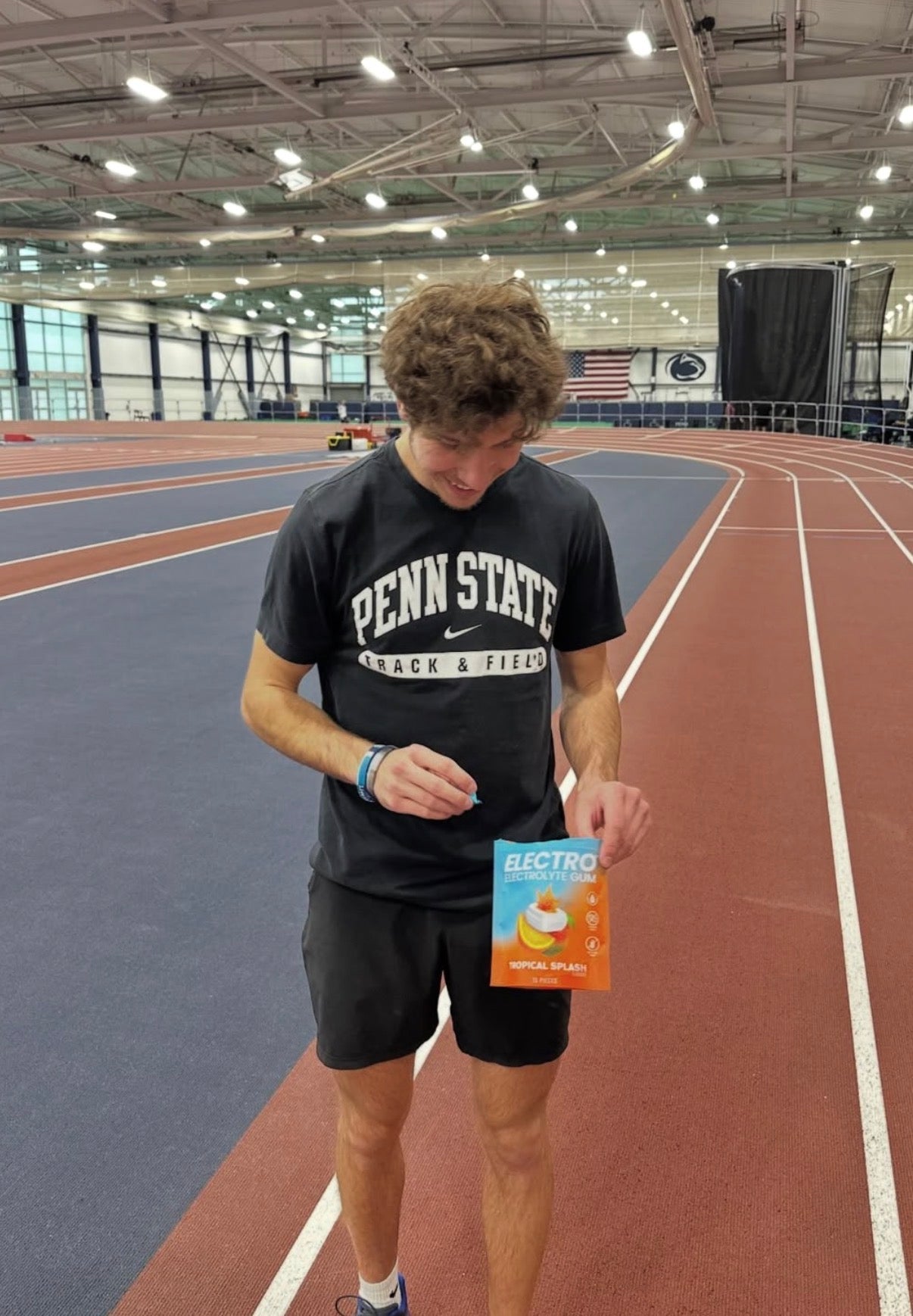 Penn State Track and Field athlete opening Electro Gum on indoor track
