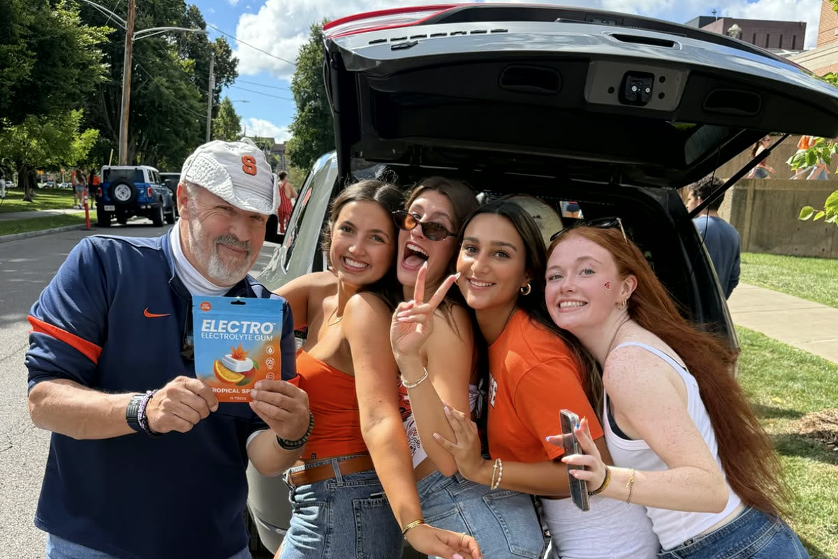 Electro interns handing out gum at a Syracuse tailgate